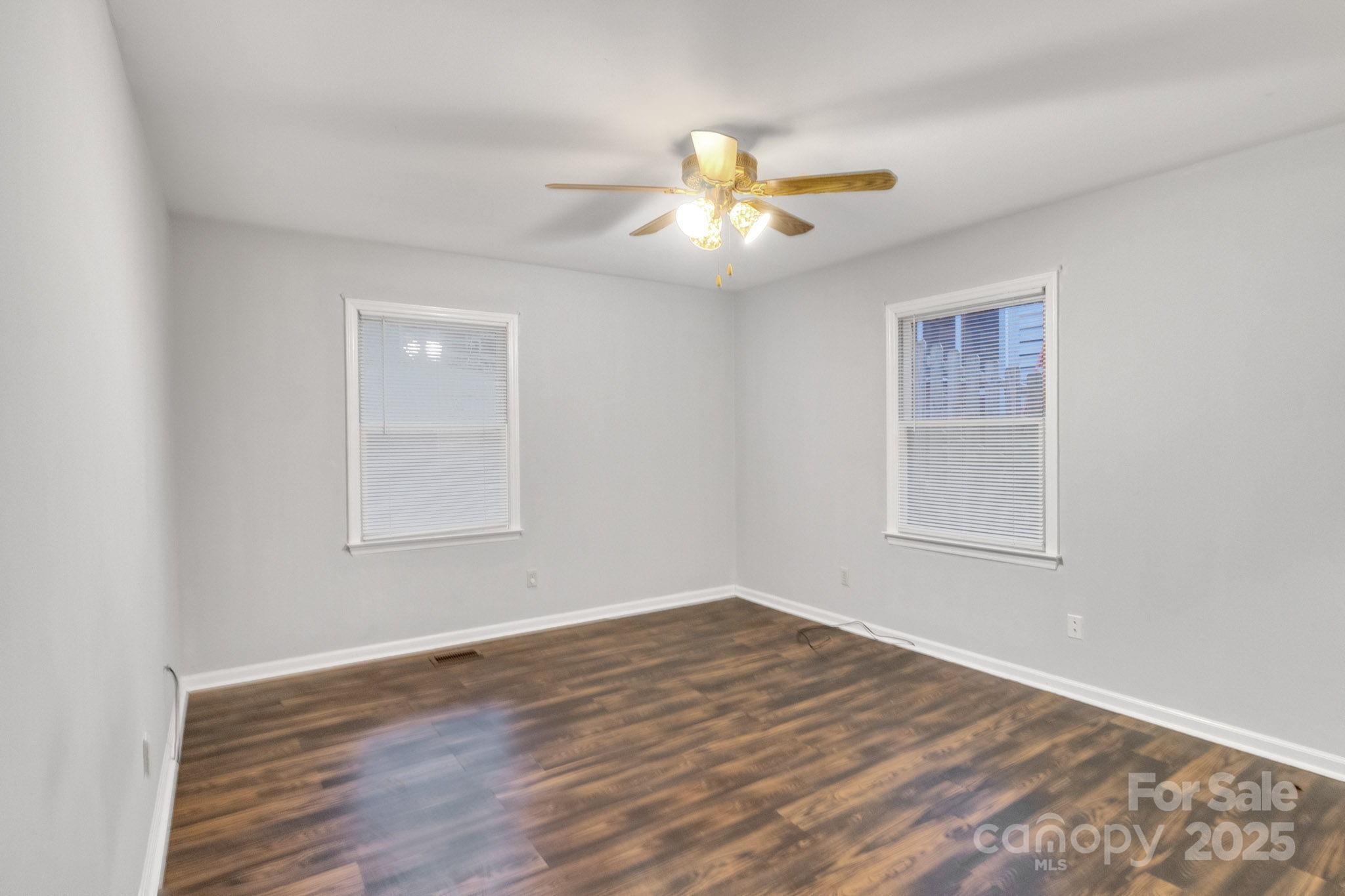 27097 Cove Lane Tega Cay, SC 29708 - Photo 22 of 30 a view of an empty room with wooden floor and a window
