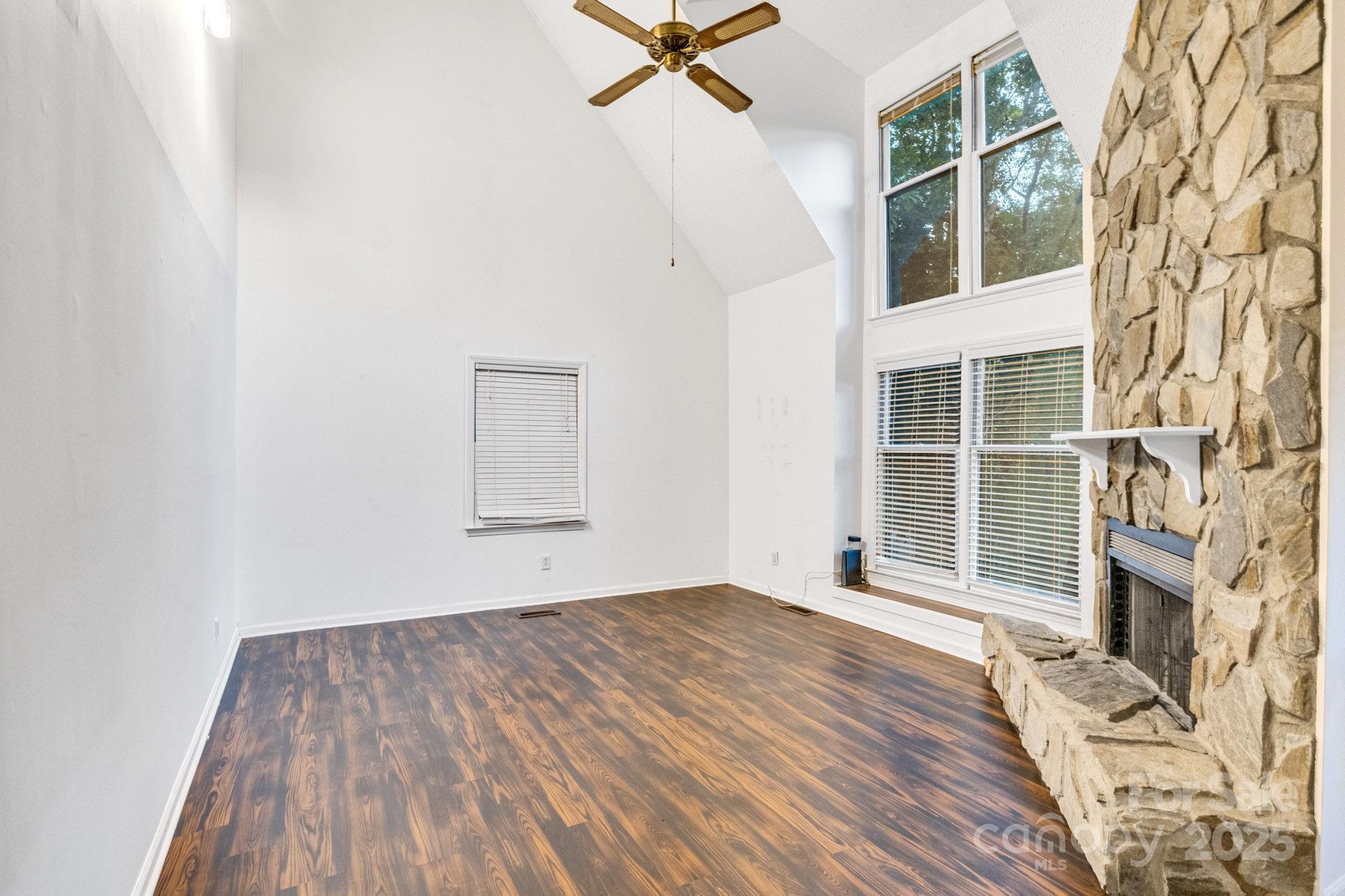 27097 Cove Lane Tega Cay, SC 29708 - Photo 10 of 30 a view of a room with wooden floor and a ceiling fan