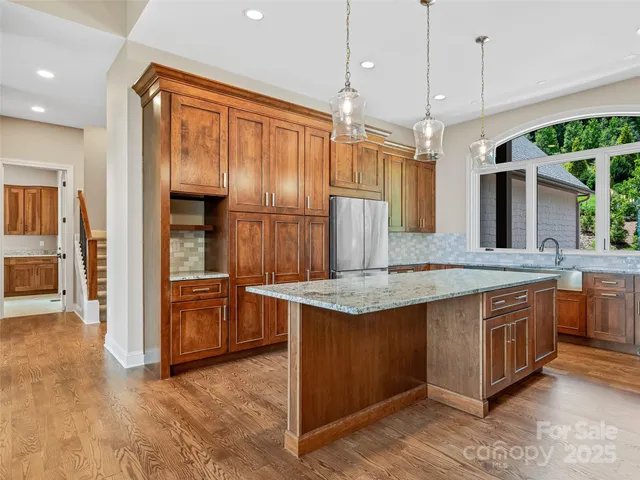 a large kitchen with stainless steel appliances granite countertop a stove and a sink