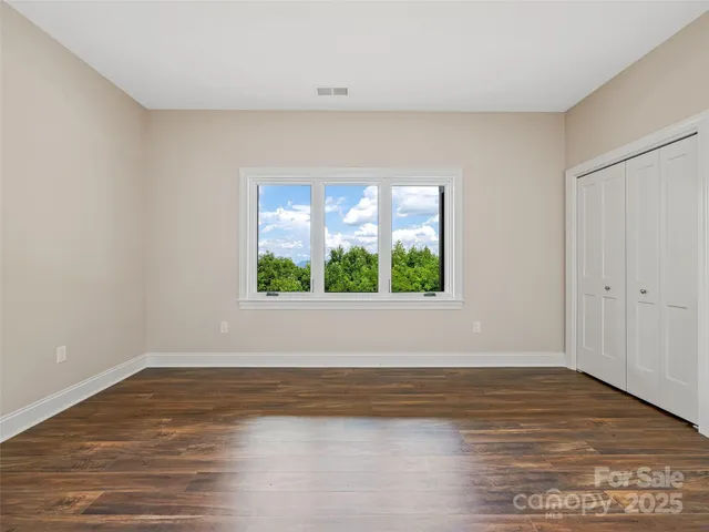 a view of room with window and wooden floor