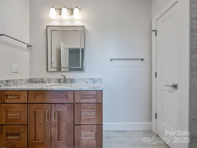 a bathroom with a granite countertop sink and a mirror