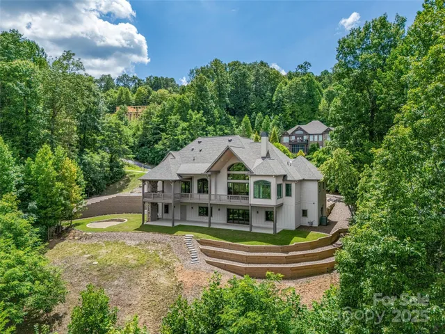 a front view of a house with a garden and trees