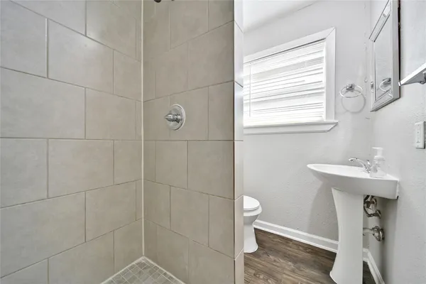 a bathroom with a sink a toilet and shower