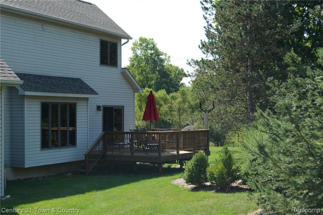 1550 East Rattalee Lake Road Holly, MI 48442 - Photo 53 of 59 2ND DECK OFF DINING ROOM TO BACK YARD- ALL BLUE SPRUCE PINES TO THE RIGHT OF THIS PHOTO ARE NEW WITH IN THE LAST 2 YEARS. $7,500 VALUE!! BELL POST DOES NOT STAY WITH SALE!