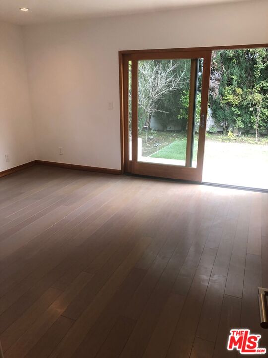 128 South Carson Road Beverly Hills, CA 90211 - Photo 13 of 20 wooden floor in an empty room with a window