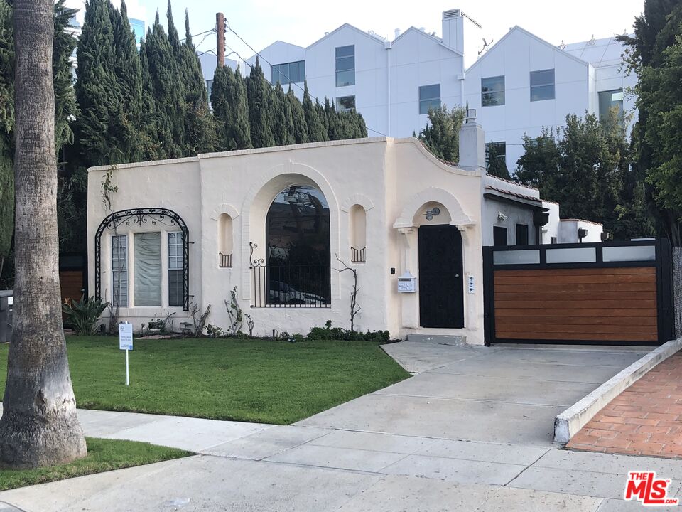 128 South Carson Road Beverly Hills, CA 90211 - Photo 3 of 20 a front view of a house with a yard