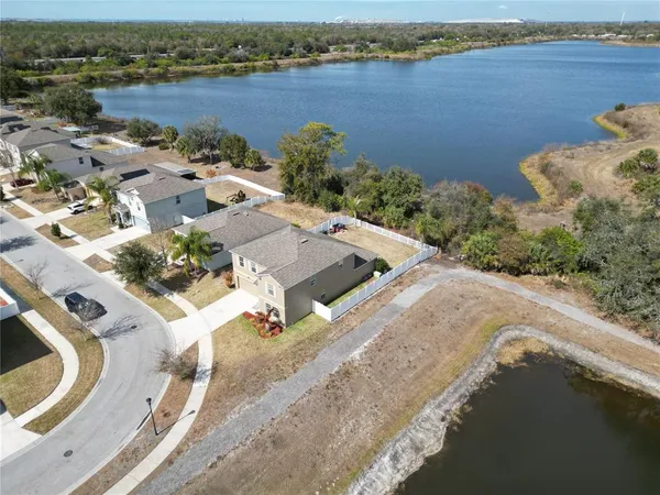 an aerial view of a house with a yard and lake view