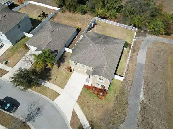 an aerial view of a house with a garden and lake view