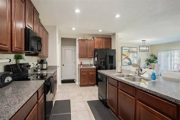 a kitchen with stainless steel appliances granite countertop a refrigerator and a stove top oven