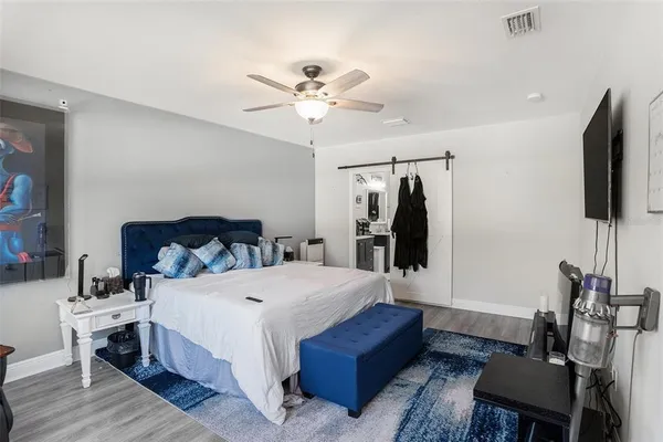 a bedroom with a bed a television and a large window