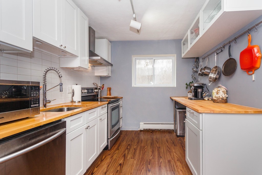 39 Westgate Road, Unit 6 Boston, MA 02467 - Photo 3 of 8 a kitchen with stainless steel appliances granite countertop a sink a stove and cabinets
