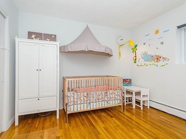 39 Westgate Road, Unit 6 Boston, MA 02467 - Photo 7 of 8 a bedroom with a bed and wooden floor