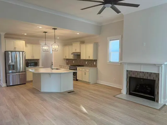 a large kitchen with a refrigerator a stove top oven a sink and dishwasher