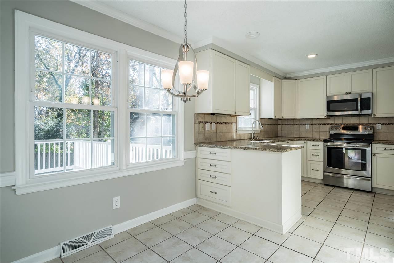 7212 St Ledger Drive Raleigh, NC 27613 - Photo 11 of 27 a kitchen with granite countertop a stove a sink and a refrigerator