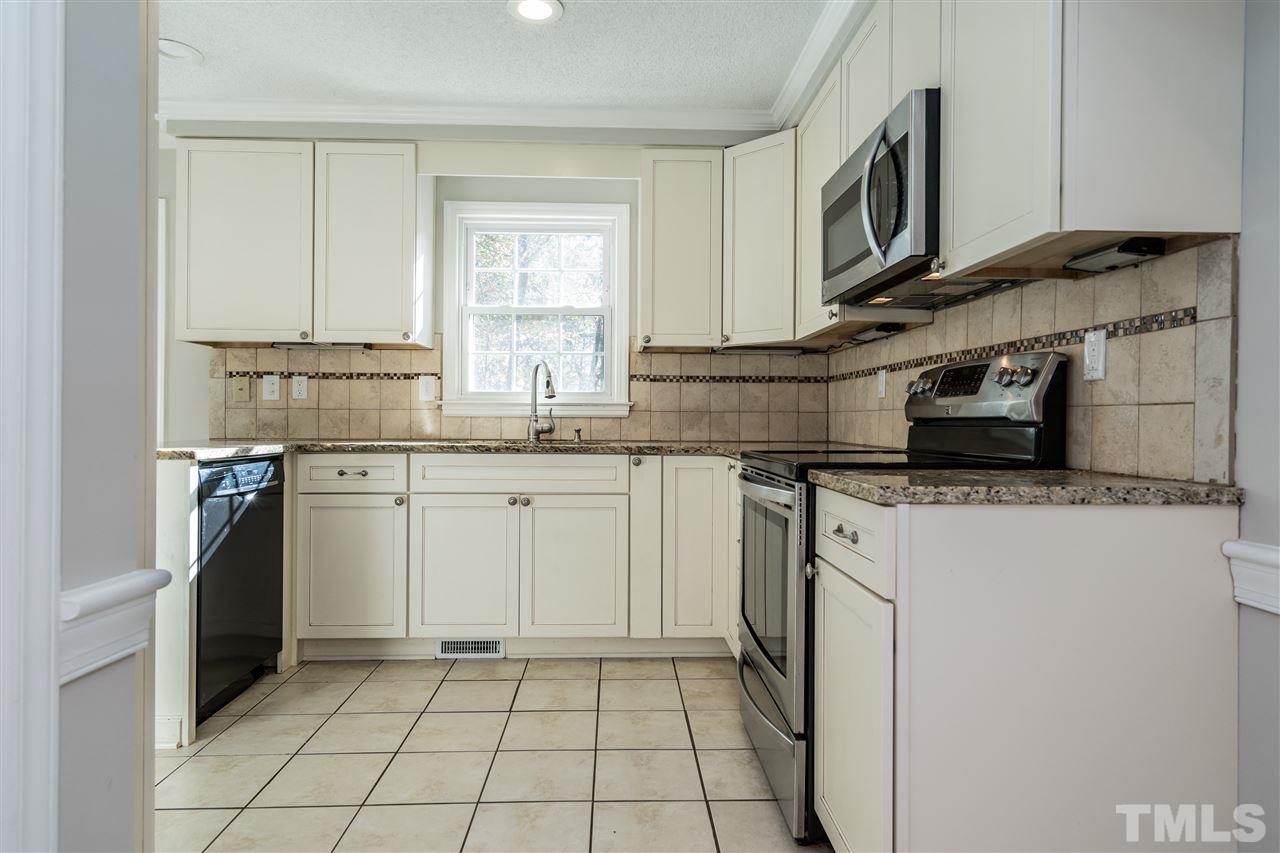 7212 St Ledger Drive Raleigh, NC 27613 - Photo 12 of 27 a kitchen with stainless steel appliances granite countertop a sink stove and refrigerator