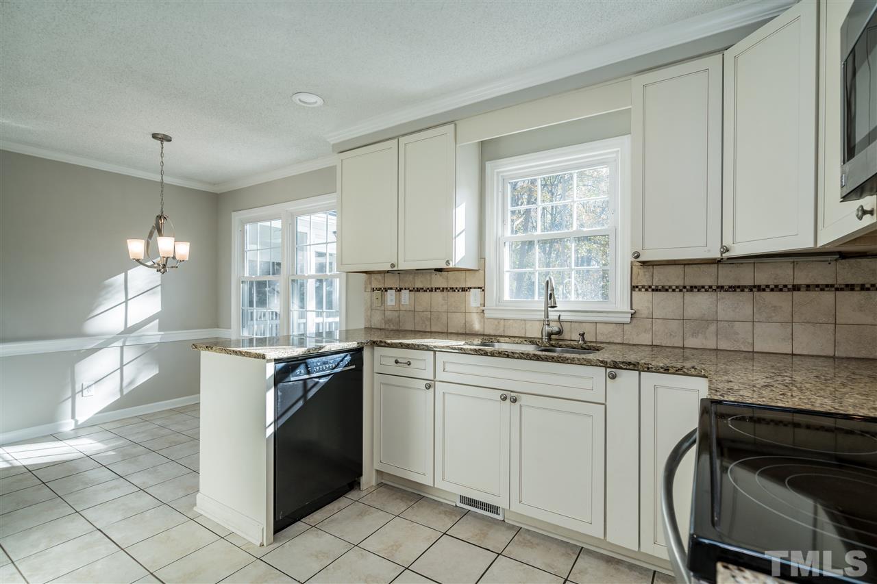 7212 St Ledger Drive Raleigh, NC 27613 - Photo 13 of 27 a kitchen with granite countertop a sink stove and cabinets