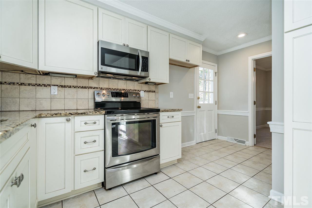 7212 St Ledger Drive Raleigh, NC 27613 - Photo 14 of 27 a kitchen with white cabinets stainless steel appliances and sink