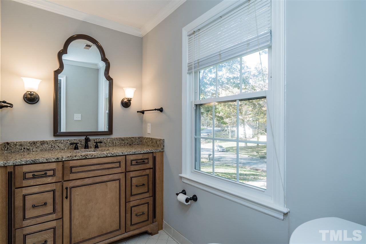 7212 St Ledger Drive Raleigh, NC 27613 - Photo 19 of 27 a bathroom with a granite countertop sink a large mirror a and a window
