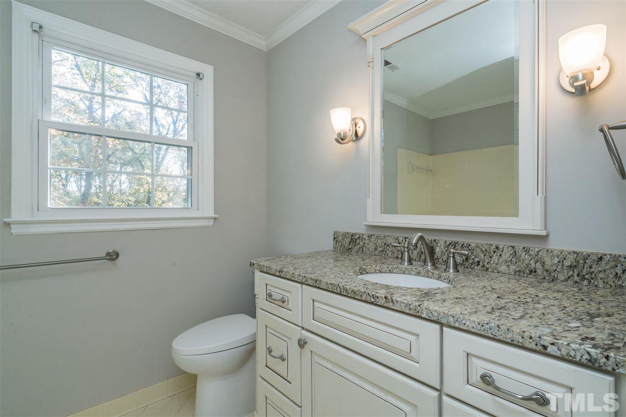 7212 St Ledger Drive Raleigh, NC 27613 - Photo 22 of 27 a bathroom with a granite countertop toilet sink and mirror