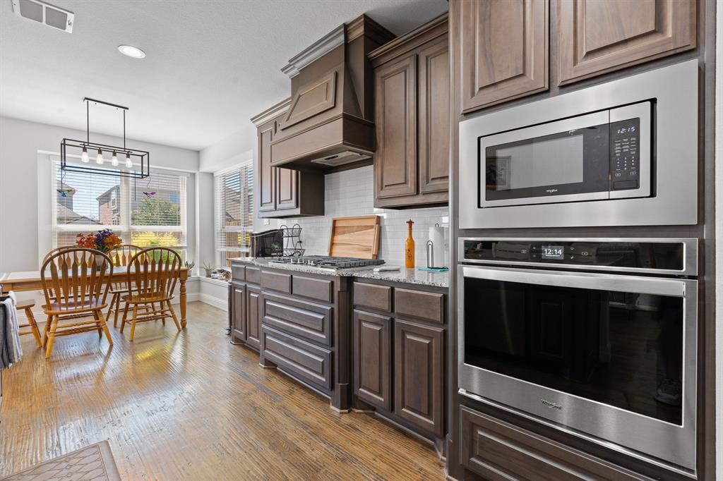 15105 Fleet Hill Road Aledo, TX 76008 - Photo 11 of 31 a kitchen with granite countertop wooden cabinets stainless steel appliances and wooden floor
