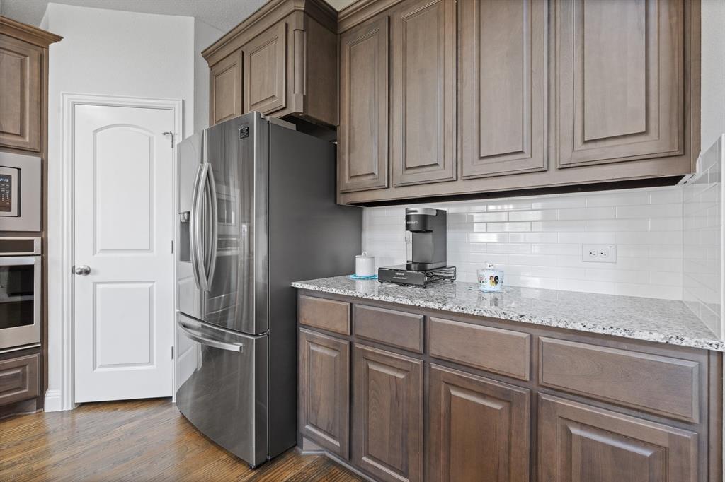 15105 Fleet Hill Road Aledo, TX 76008 - Photo 12 of 31 a kitchen with stainless steel appliances granite countertop a refrigerator and cabinets