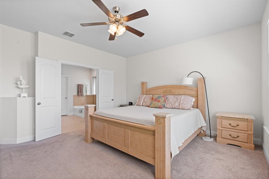 15105 Fleet Hill Road Aledo, TX 76008 - Photo 17 of 31 a bedroom with a bed and a chandelier