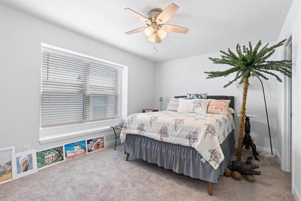 15105 Fleet Hill Road Aledo, TX 76008 - Photo 22 of 31 a bedroom with a large bed and a chandelier fan