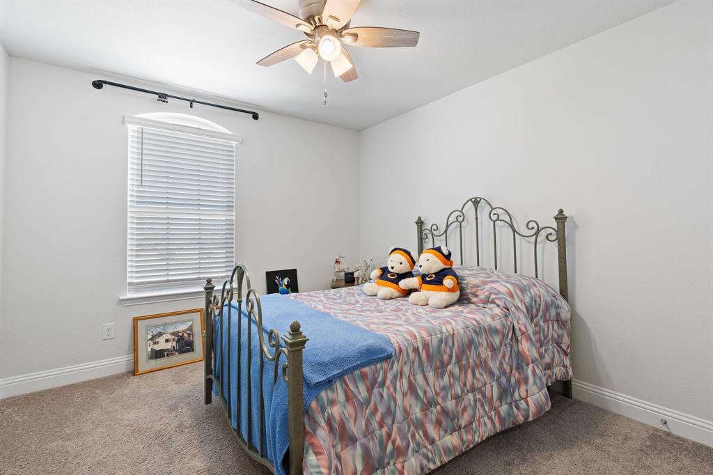 15105 Fleet Hill Road Aledo, TX 76008 - Photo 23 of 31 a bedroom with a bed and a chandelier