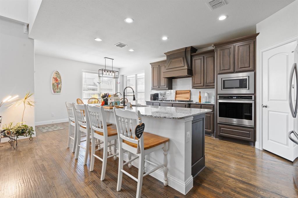 15105 Fleet Hill Road Aledo, TX 76008 - Photo 9 of 31 a kitchen with stainless steel appliances a stove a sink a refrigerator with a dining table and chairs