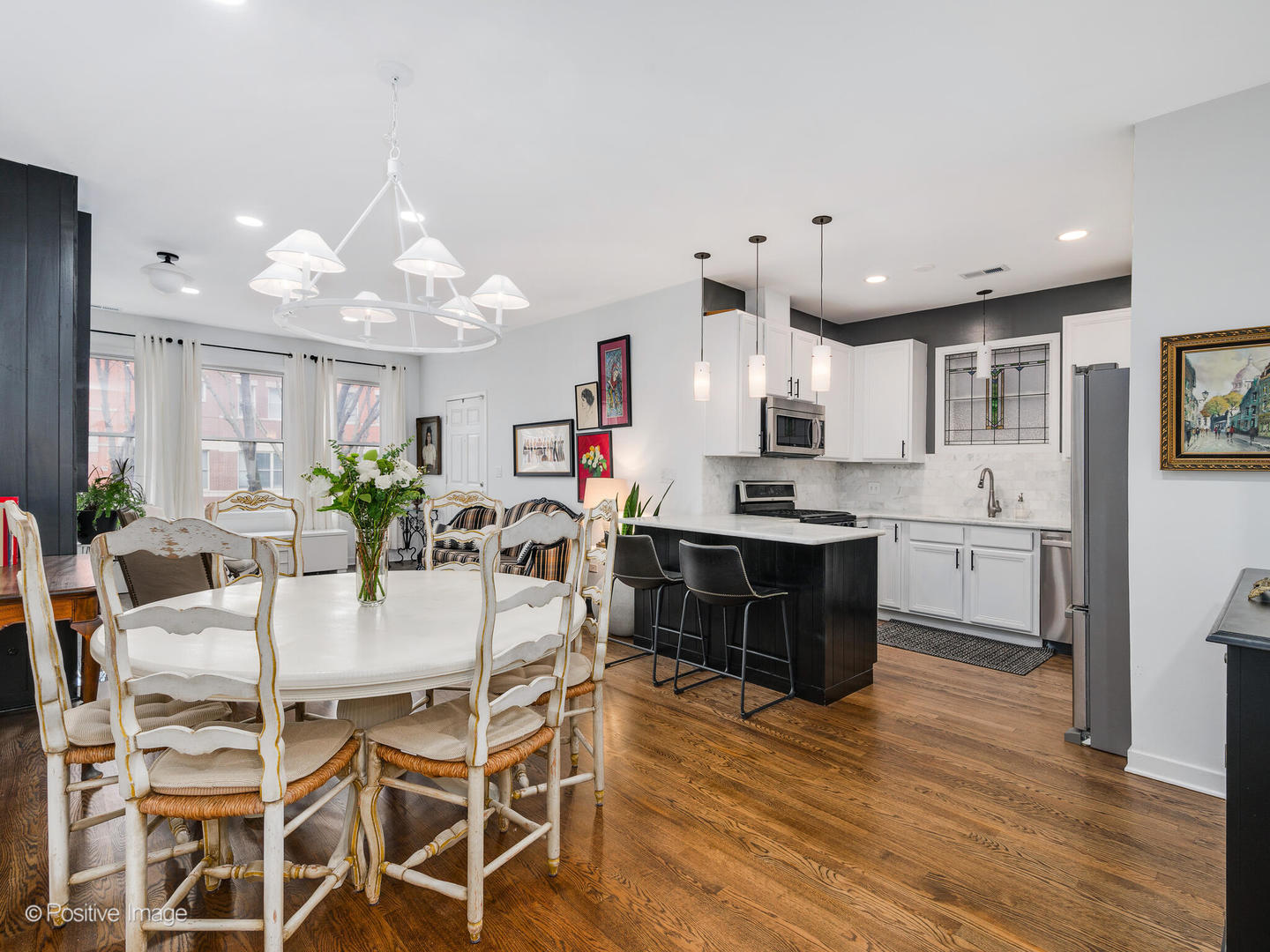 1349 West Fillmore Street, Unit B Chicago, IL 60607 - Photo 7 of 19 a kitchen with stainless steel appliances kitchen island granite countertop a refrigerator a stove a sink dishwasher and white cabinets with wooden floor