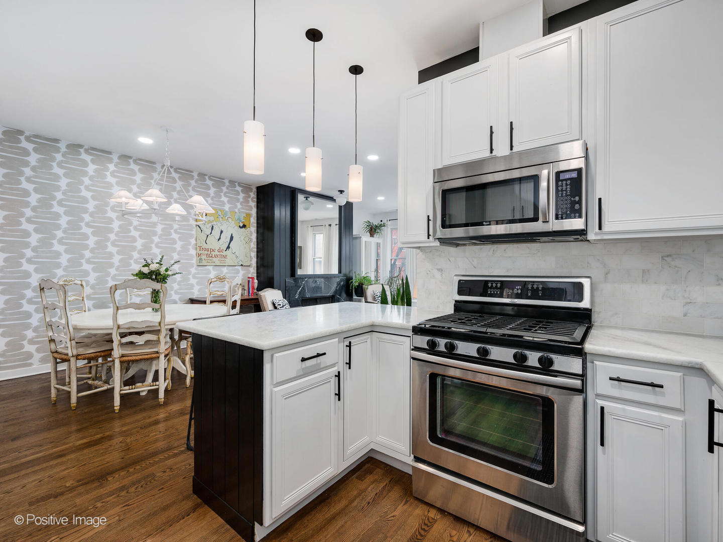 1349 West Fillmore Street, Unit B Chicago, IL 60607 - Photo 9 of 19 a kitchen with stainless steel appliances a stove a microwave and white cabinets