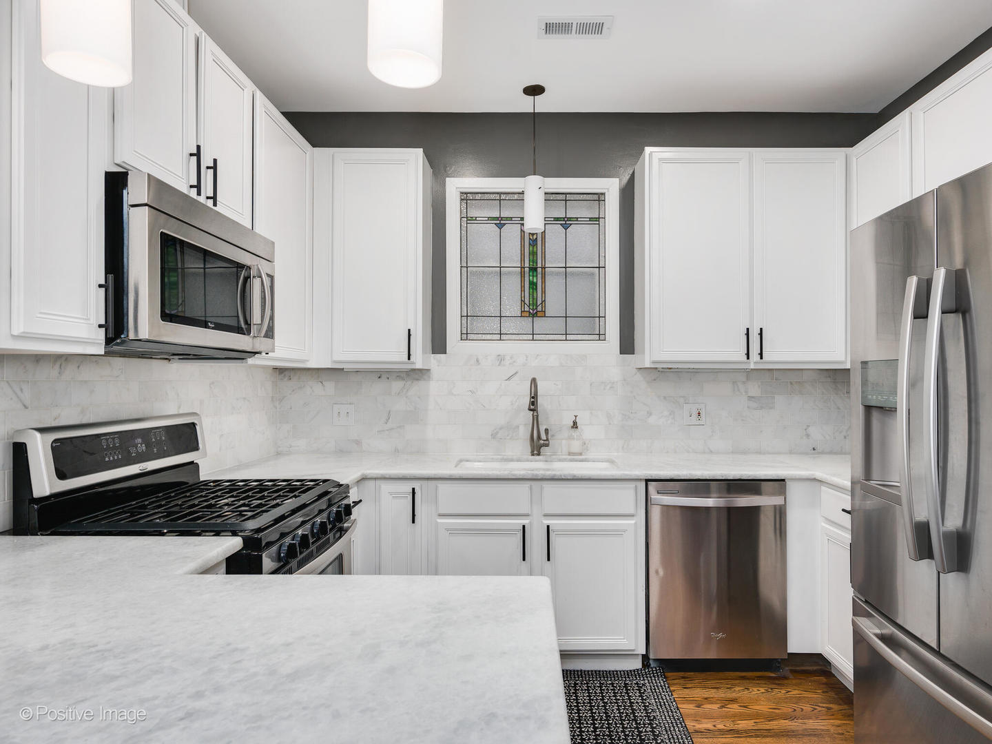 1349 West Fillmore Street, Unit B Chicago, IL 60607 - Photo 10 of 19 a kitchen with stainless steel appliances granite countertop a stove a sink and a microwave