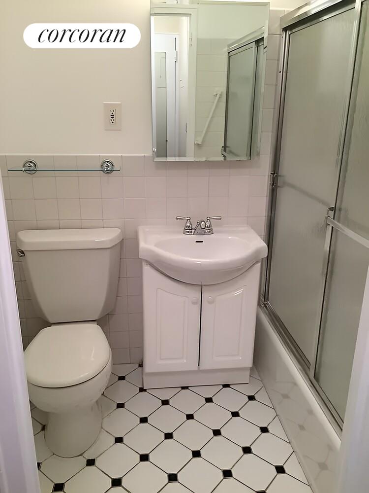 220 East 60th Street, Unit 4F Manhattan, NY 10022 - Photo 4 of 7 a bathroom with a toilet a sink and a mirror
