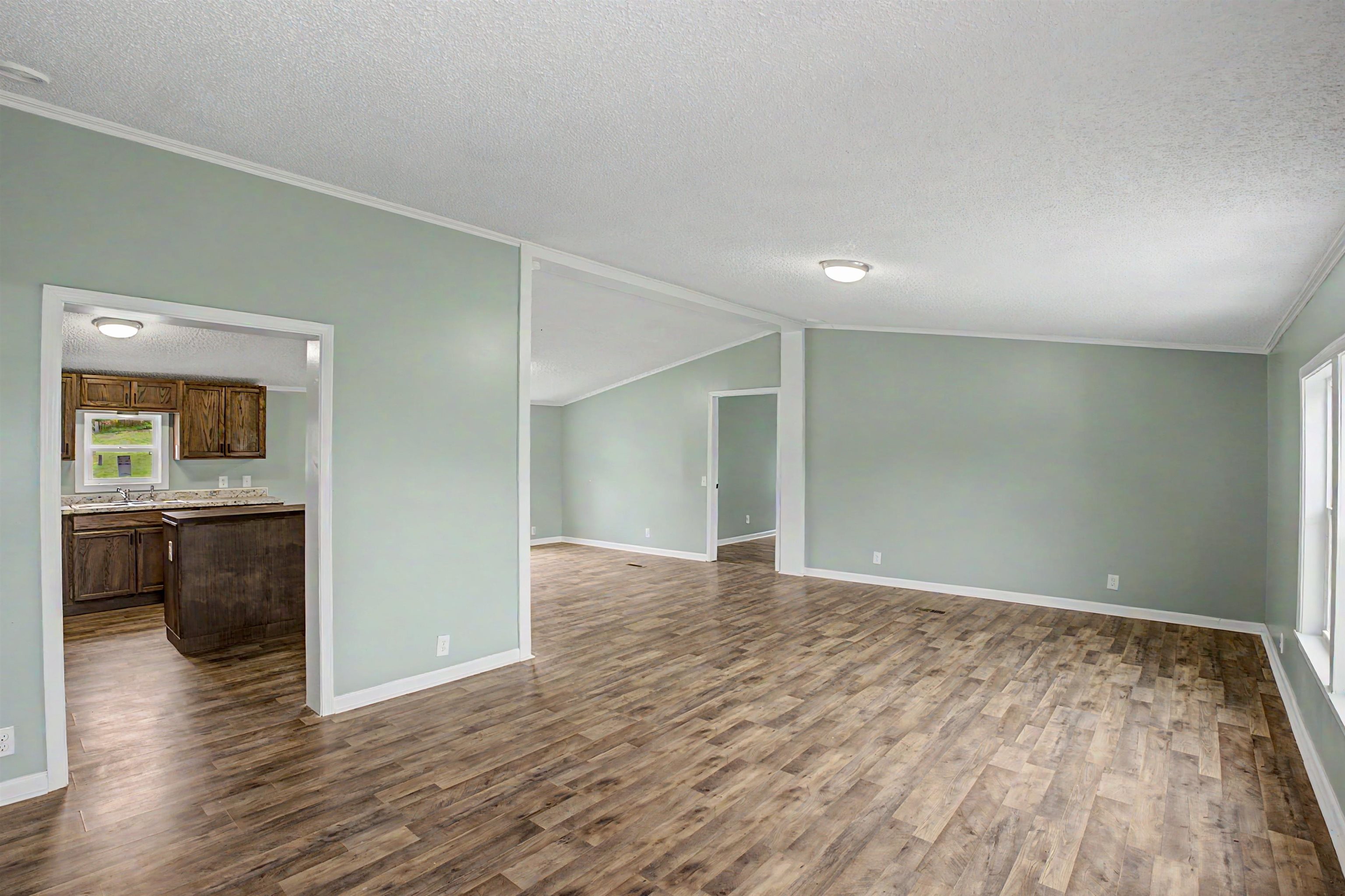 1090 Scott Road Newbern, TN 38059 - Photo 3 of 16 Unfurnished living room with ornamental molding and dark wood-style floors