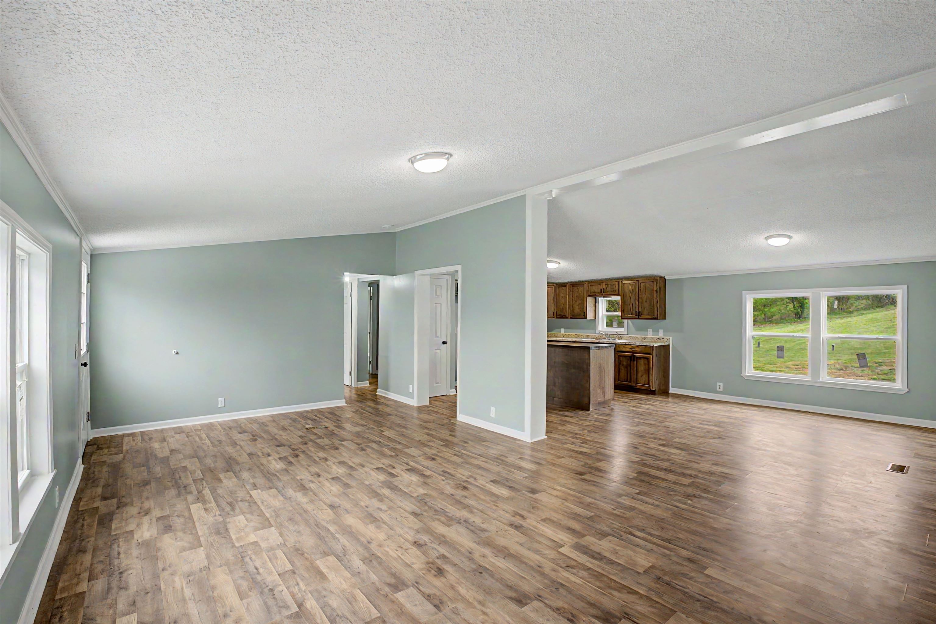 1090 Scott Road Newbern, TN 38059 - Photo 4 of 16 Unfurnished living room featuring dark wood-style flooring and ornamental molding