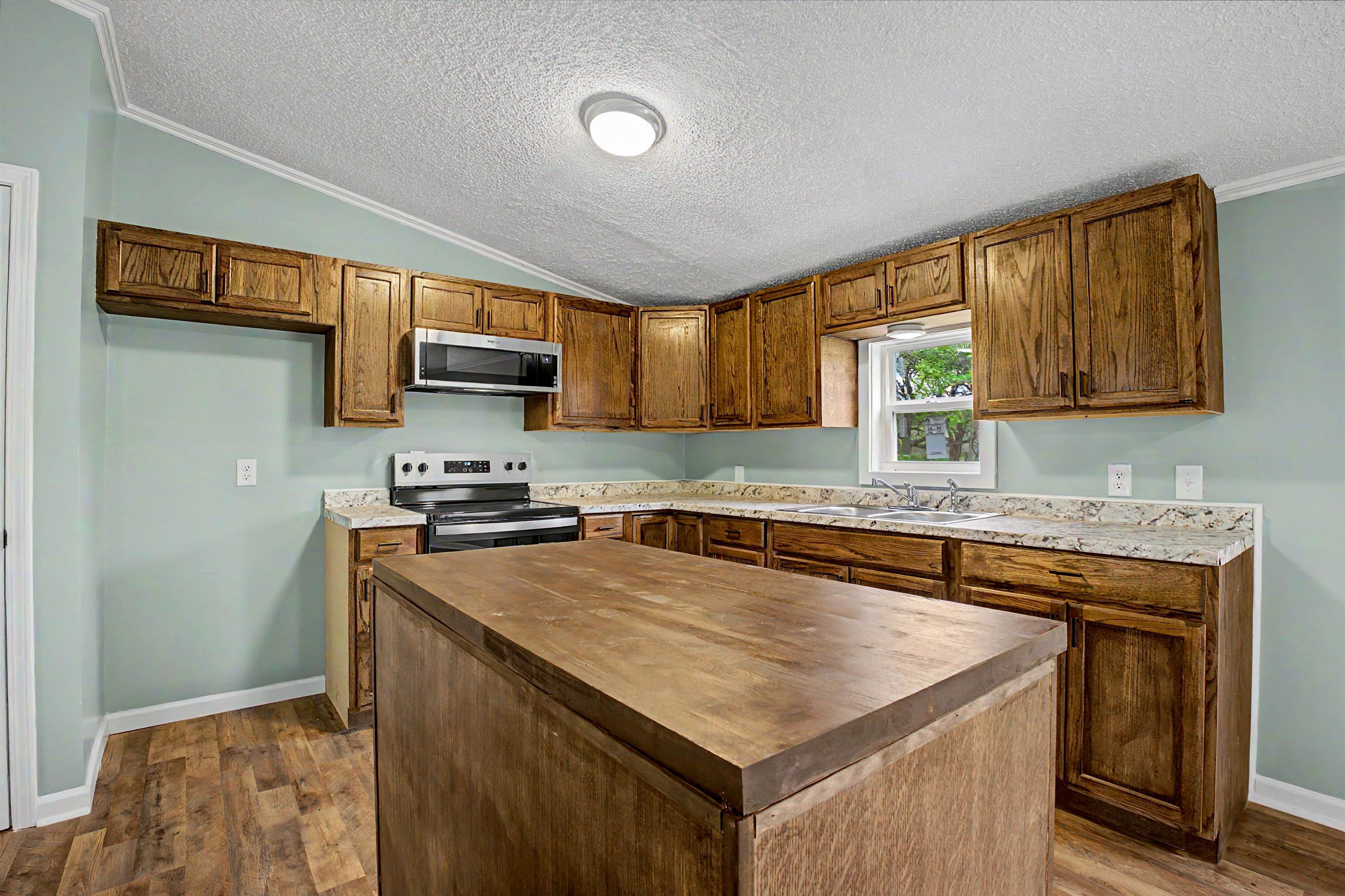 1090 Scott Road Newbern, TN 38059 - Photo 5 of 16 Kitchen with wood counters, stainless steel appliances, a center island, dark wood-style floors, and crown molding