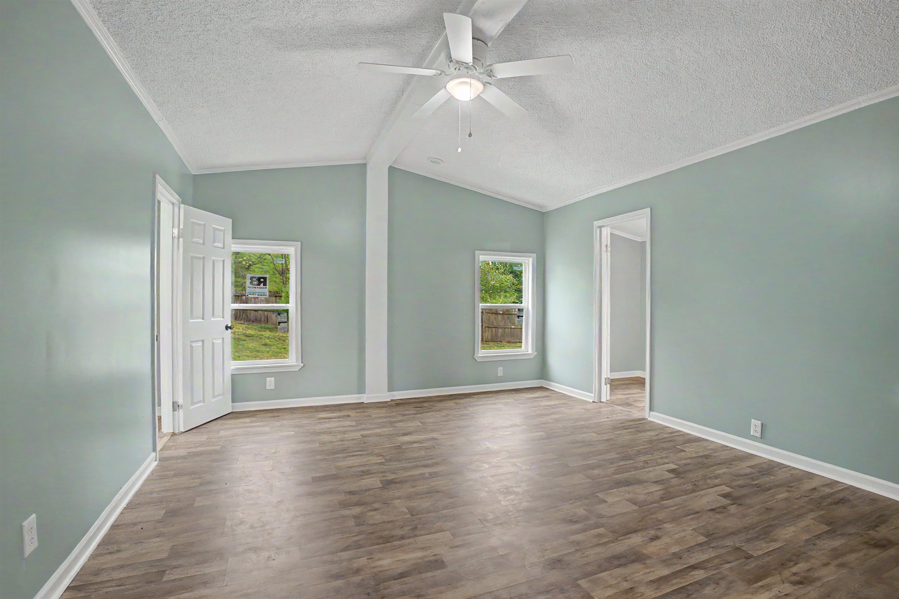1090 Scott Road Newbern, TN 38059 - Photo 8 of 16 Unfurnished room with ornamental molding, dark wood-style flooring, ceiling fan, plenty of natural light, and a textured ceiling