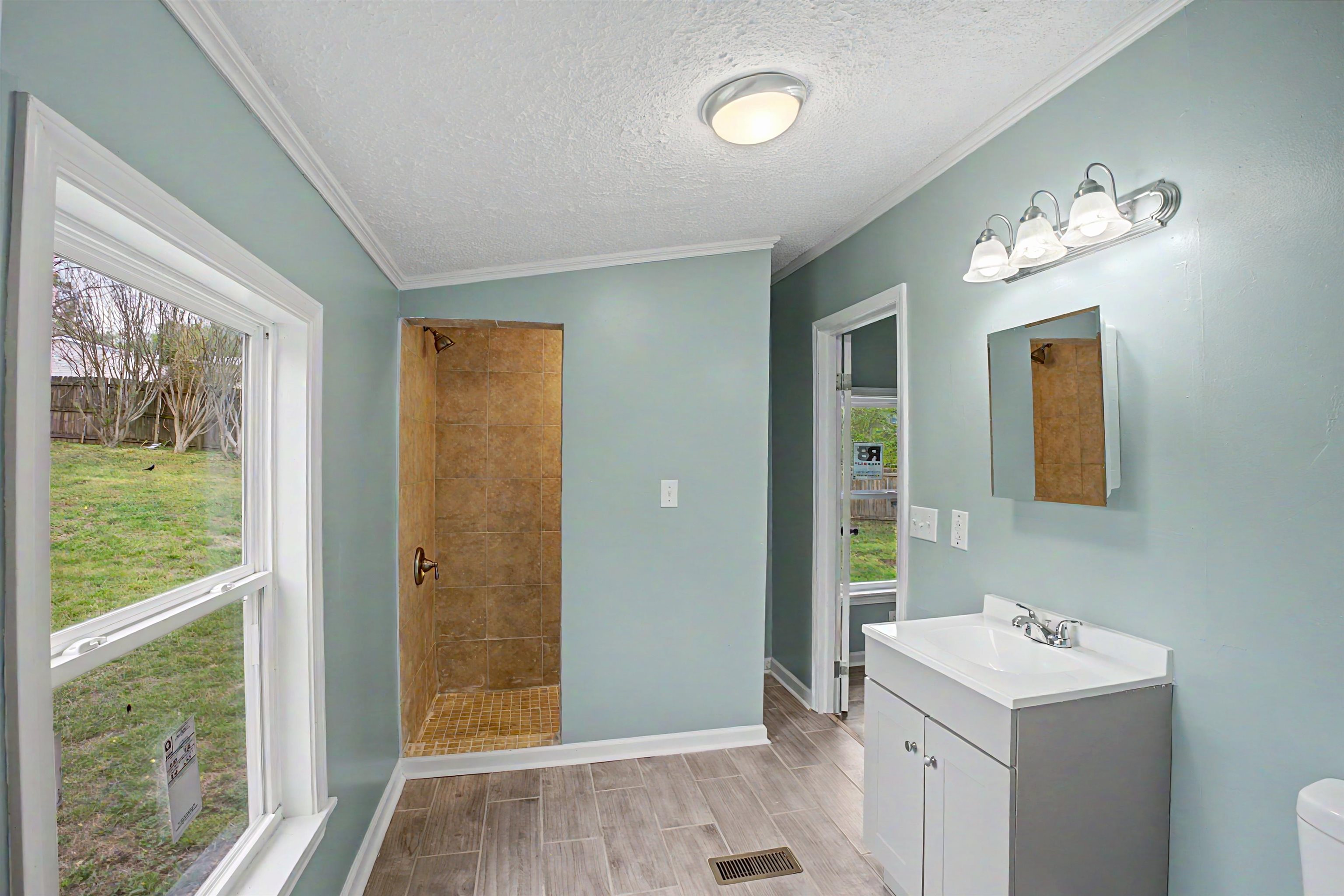 1090 Scott Road Newbern, TN 38059 - Photo 9 of 16 Full bathroom featuring vanity, wood tiled floors, tiled shower, a textured ceiling, and crown molding