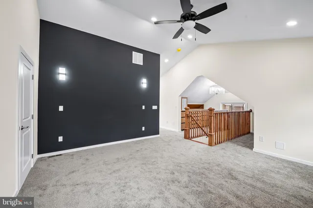 an empty room with a ceiling fan and entryway