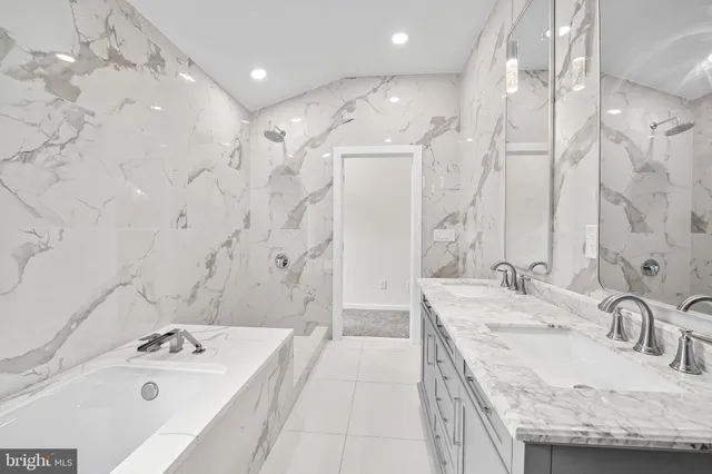 a bathroom with a granite countertop double vanity sink and a mirror
