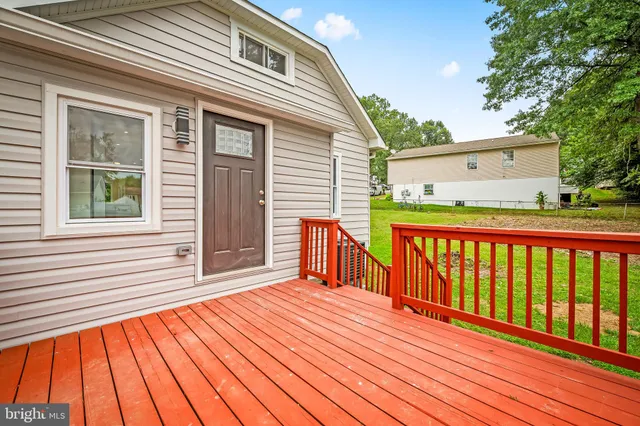 a balcony with wooden floor and trees in the back