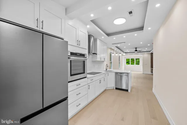 a kitchen with white cabinets and stainless steel appliances