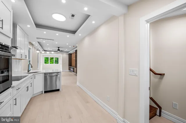 a large white kitchen with lots of counter space and window