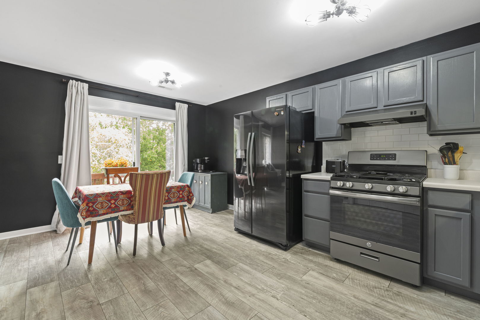 1940 Matthew Court, Unit D Elgin, IL 60123 - Photo 5 of 15 a kitchen with stainless steel appliances granite countertop a stove a refrigerator a kitchen island a table and chairs