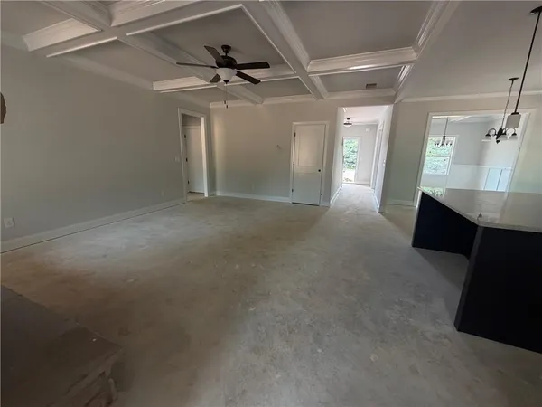 en empty room with windows and ceiling fan