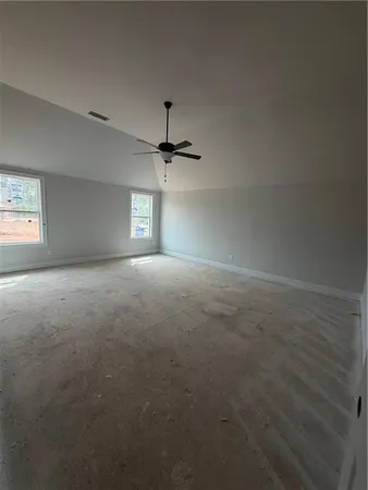 a view of empty room with windows and ceiling fan