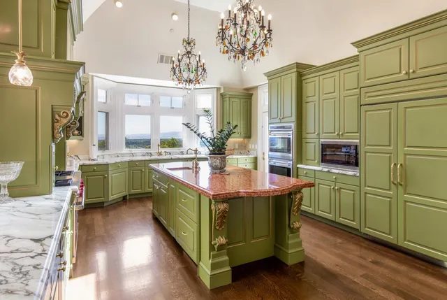 a room with kitchen island granite countertop a sink a counter space and stainless steel appliances
