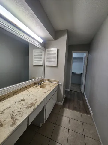 a bathroom with a granite countertop sink and a toilet