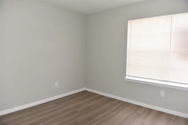 a view of a small space with wooden floor and a window