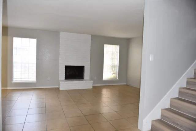 a view of an empty room with a window and a fireplace